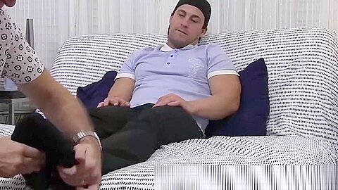 Hunky dude receives a skillful foot massage from his friend