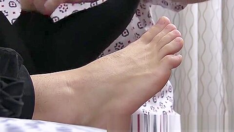 Hunky dude receives a skillful foot massage from his friend