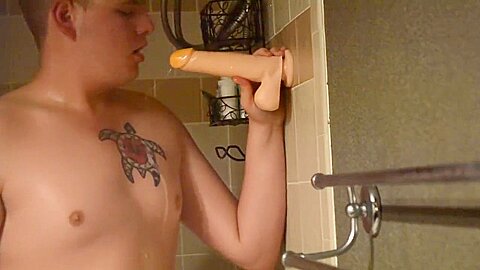 Shaved twink practices deepthroating in the shower