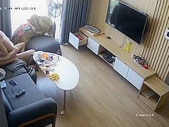 Young couple in livingroom, riding on sofa