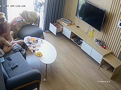 Young couple in livingroom, riding on sofa