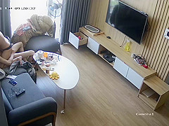 Young couple in livingroom, riding on sofa
