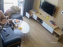 Young couple in livingroom, riding on sofa