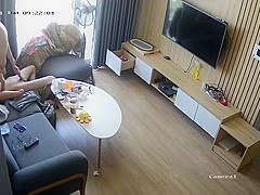 Young couple in livingroom, riding on sofa